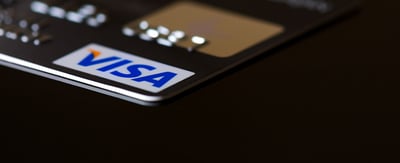 A Visa payment card sitting on a black surface