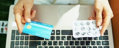 credit card and pills over laptop