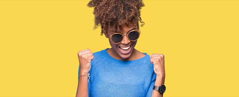 woman in sunglasses holding fists in victory